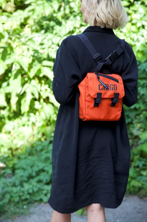 kobieta ze stylową pomarańczową listonoszką mini plecak z cordury cargo by owee na tle roślin