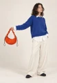 CARGO SCRUNCH SMALL ORANGE — torba noszona do ręki przez modelkę