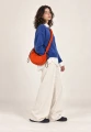 CARGO SCRUNCH SMALL ORANGE — torba noszona crossbody przez modelkę
