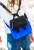Torba mini-plecak Reflective royal blue noszona na ramieniu; obok czarny wariant