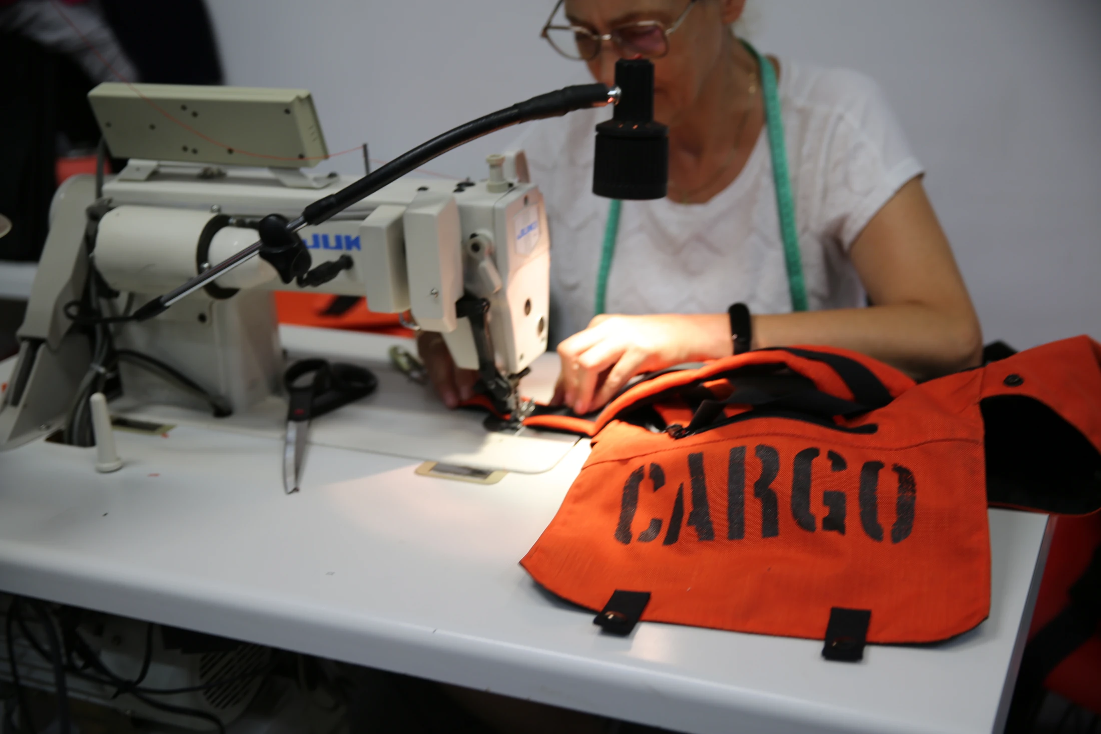 Szycie pomarańczowej torby CARGO w pracowni